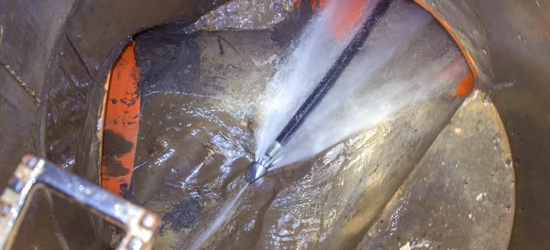 Hydro jetting nozzle spraying water inside a drain pipe