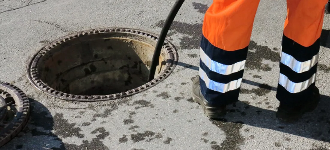 Drainage engineer in high-visibility trousers accessing a manhole for blocked drain unblocking in East Yorkshire.